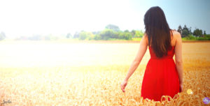 Frau im Feld mit rotem Kleid