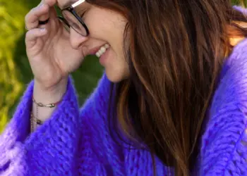 Lachende Frau im lila Wollpulli