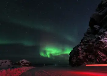 Nordlichter mit rotem Autolicht in Norwegen
