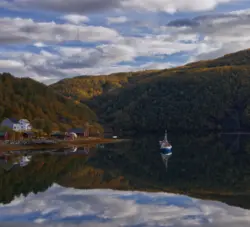 Boot auf spiegelglatter Wasseroberfläche in Norwegen