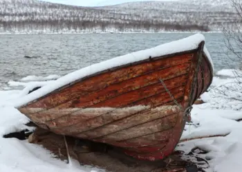 Boot im Schnee am Torneträsk See in Schweden