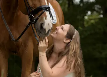 Braut sitzt vor ihrem Pferd