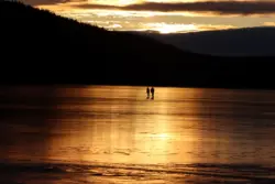 Eishockeyspieler im Sonnenuntergang auf einem See in Schweden