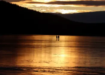 Eishockeyspieler im Sonnenuntergang auf einem See in Schweden