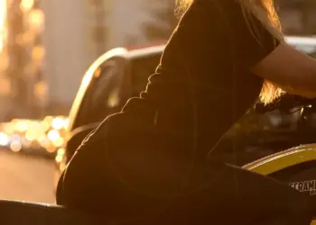 Frau auf dem Motorrad im goldenen Licht der Sonne