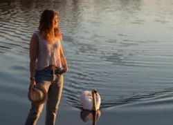 Frau im Sonnenuntergang mit einem Schwan