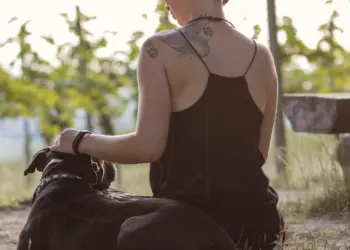 Frau mit Hund blickt in die Weinberge