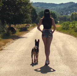 Ganzkörperaufnahme einer Frau mit ihrem Hund auf der Straße