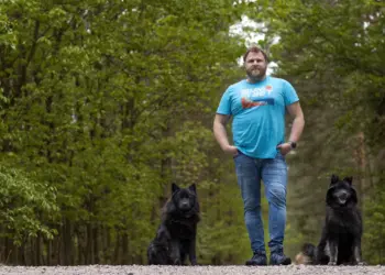 Ganzkörperaufnahme von einem Mann mit seinen beiden Hunden