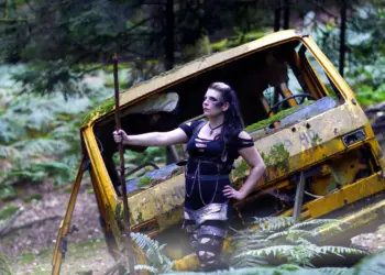 Lostplaceshooting mit einer Frau vor einem Bus im Wald