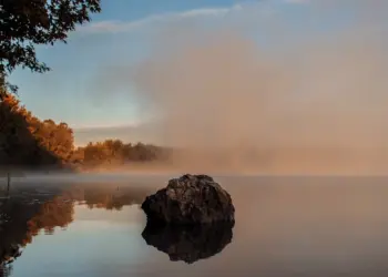 Nebellandschaft über einem See im Sonnenaufgang