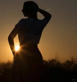 Portrait einer Frau im Gegenlicht der untergehenden Sonne