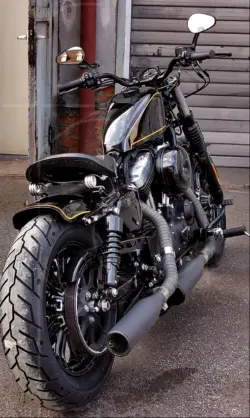 Schwarzes Motorrad vor einer Garage