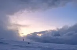 Spaziergänger im Schnee auf dem Berg im Abendlicht in Norwegen