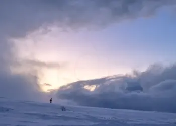 Spaziergänger im Schnee auf dem Berg im Abendlicht in Norwegen