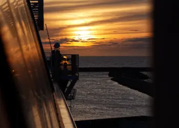 Spiegelung des Sonnenuntergangs in der Wand einer Fähre