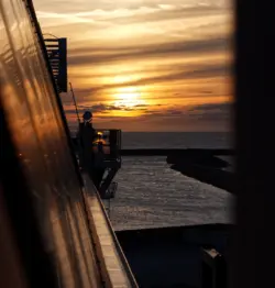 Spiegelung des Sonnenuntergangs in der Wand einer Fähre