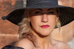 Starkes Frauenportrait mit schwarzem Hut in der Sonne