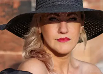 Sstarkes Frauenportrait mit schwarzem Hut in der Sonne