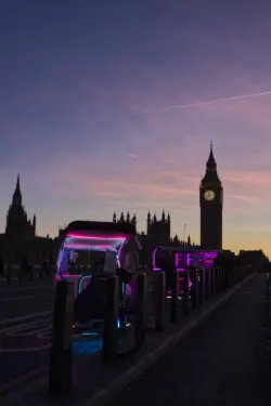 Bunte Rikschas vor dem Big Ben im Londoner Abendlicht